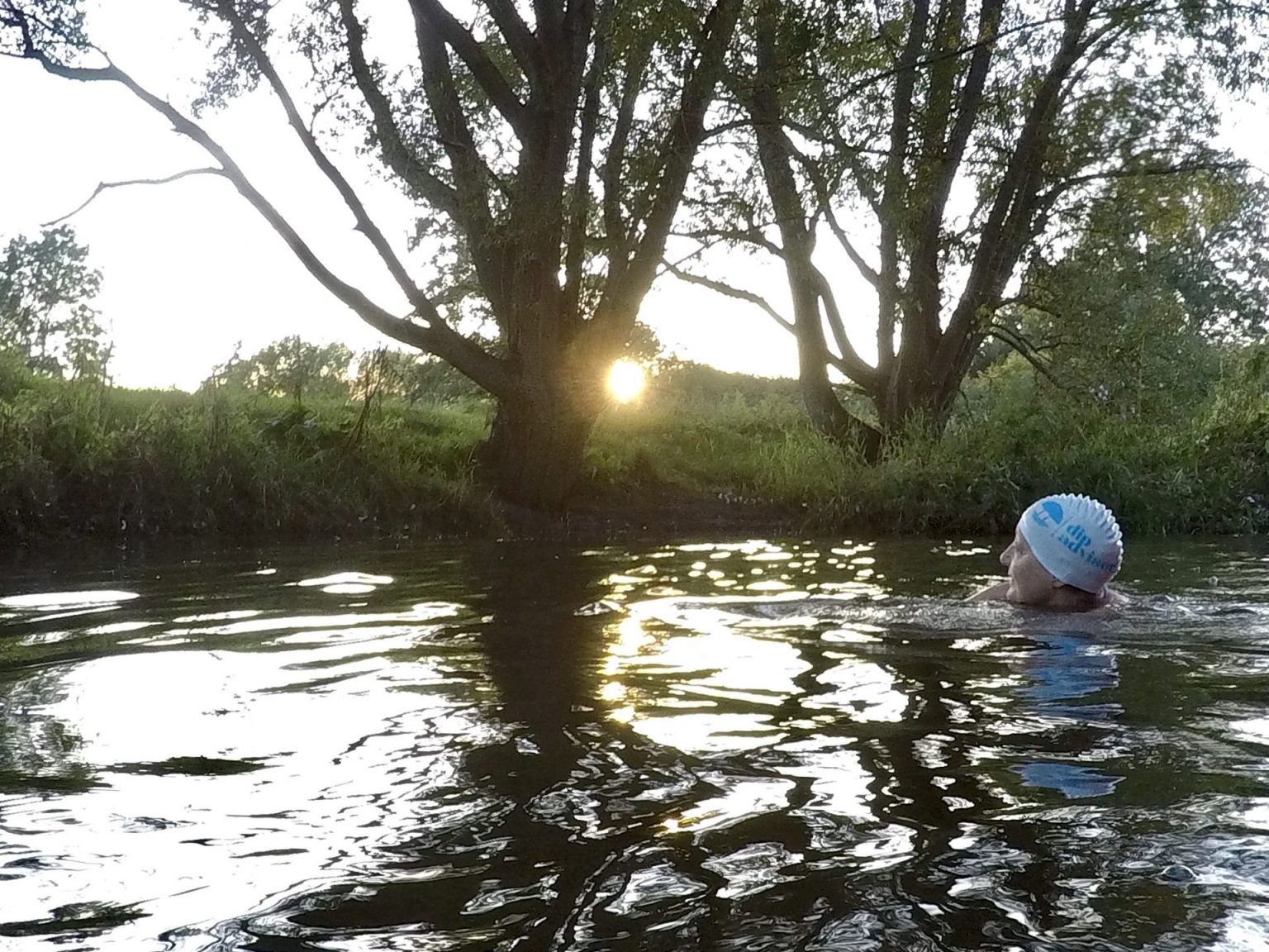 Swimmer in river at sunrise